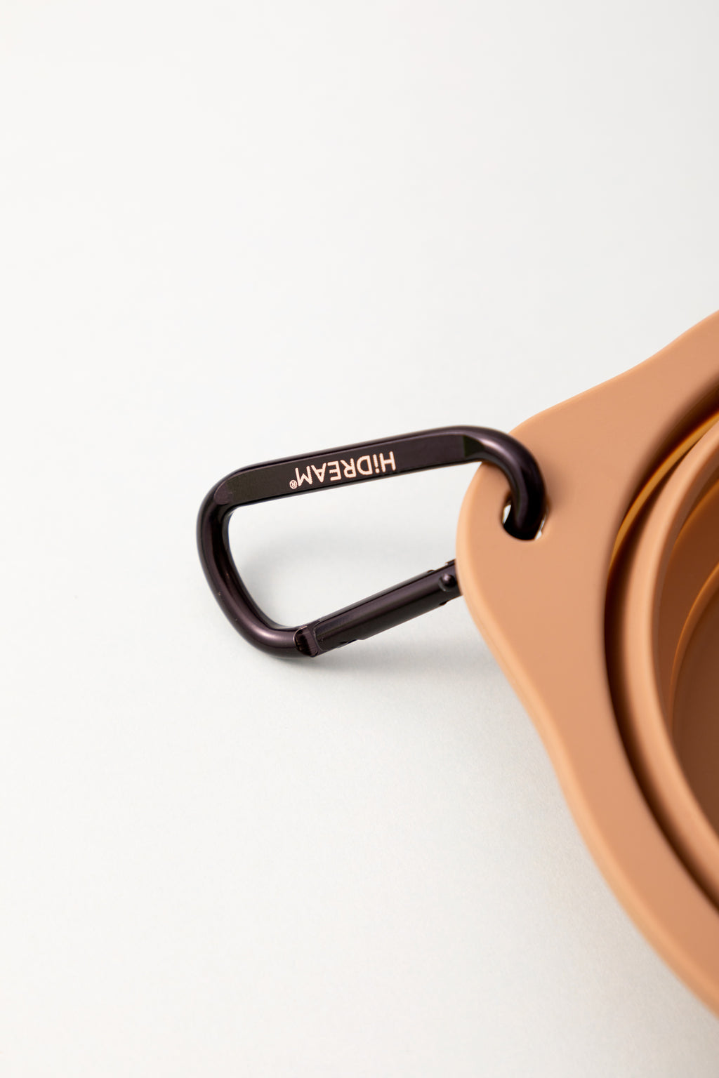 Brown collapsible silicone pet bowl shown in expanded and folded positions with carabiner clip