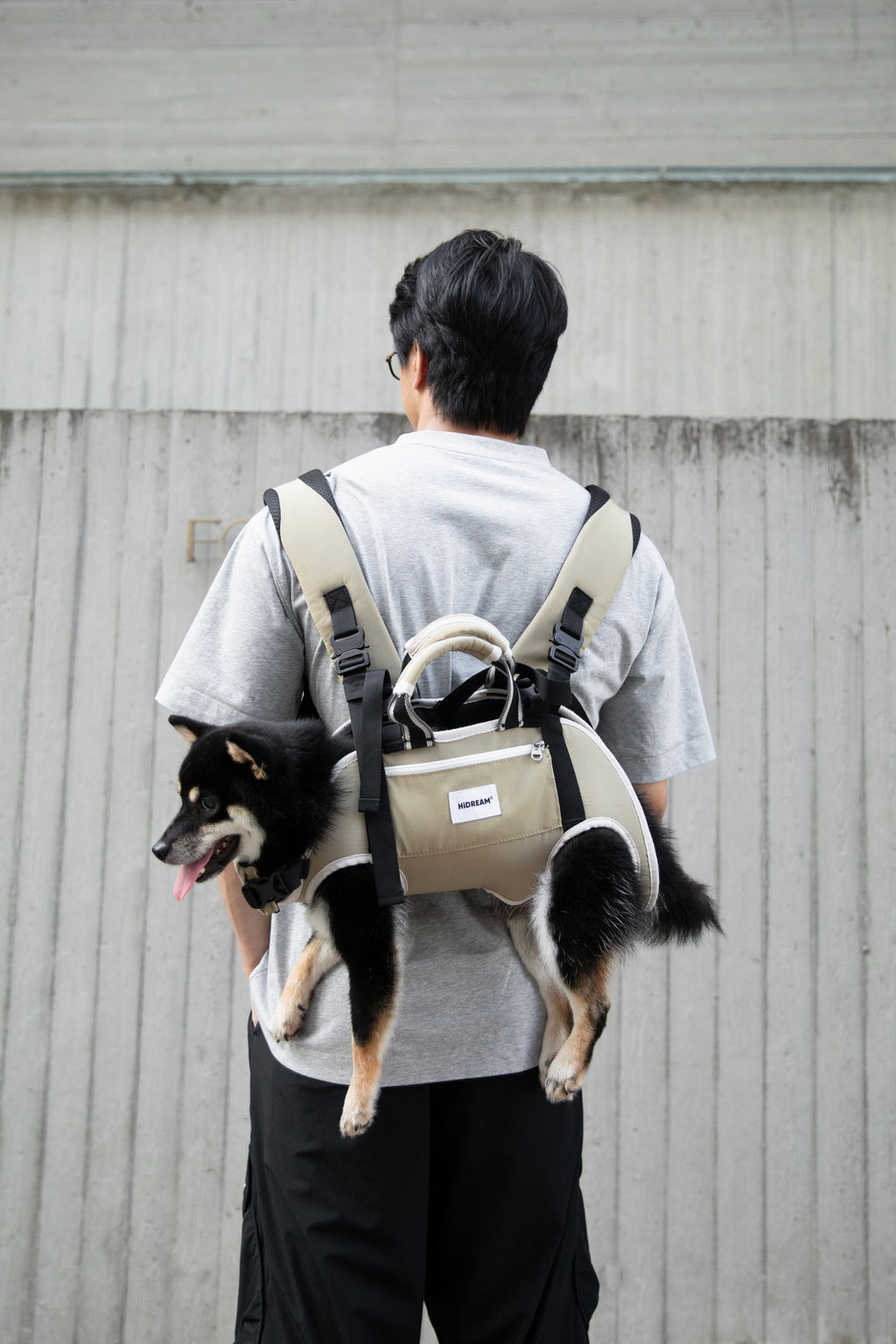 Person wearing an ergonomic pet backpack carrier outdoors