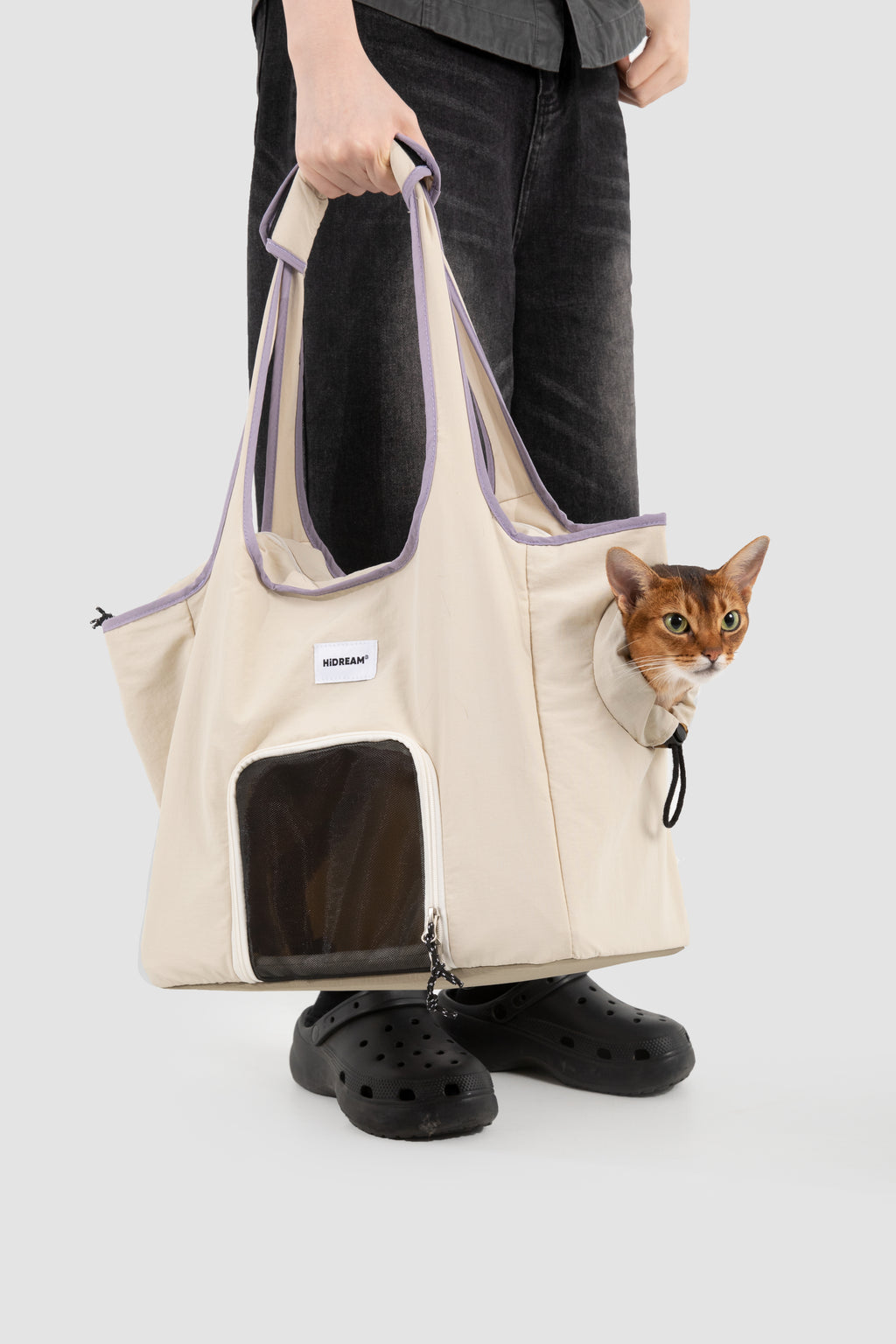 Pet tote carrier bag being carried with a small cat inside