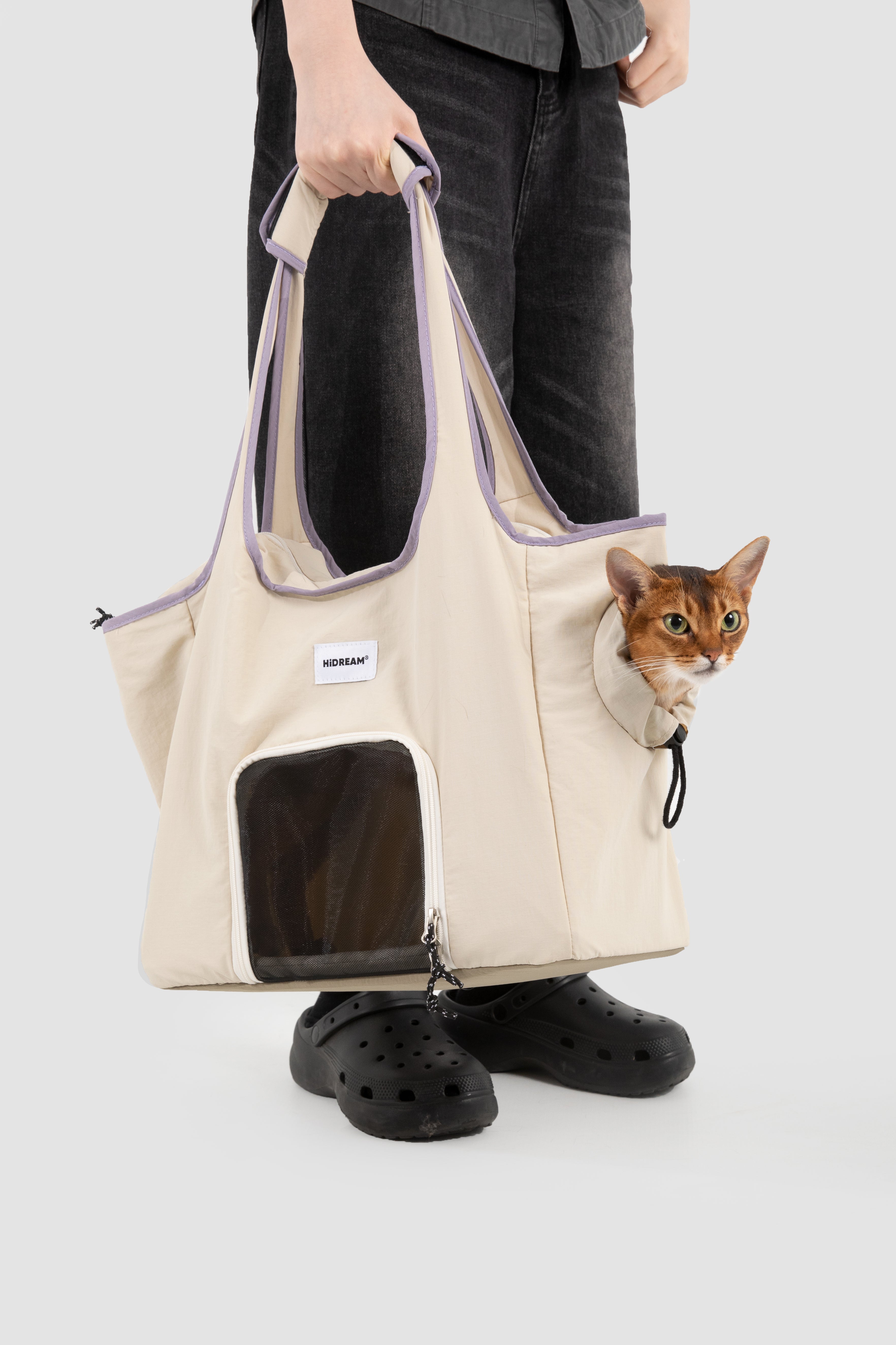 Pet tote carrier bag being carried with a small cat inside